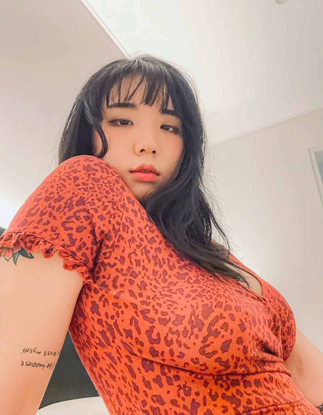 EchiH穿橙色印花服装自拍，黑色长发搭配刘海，近距离镜头突出面部和服饰造型