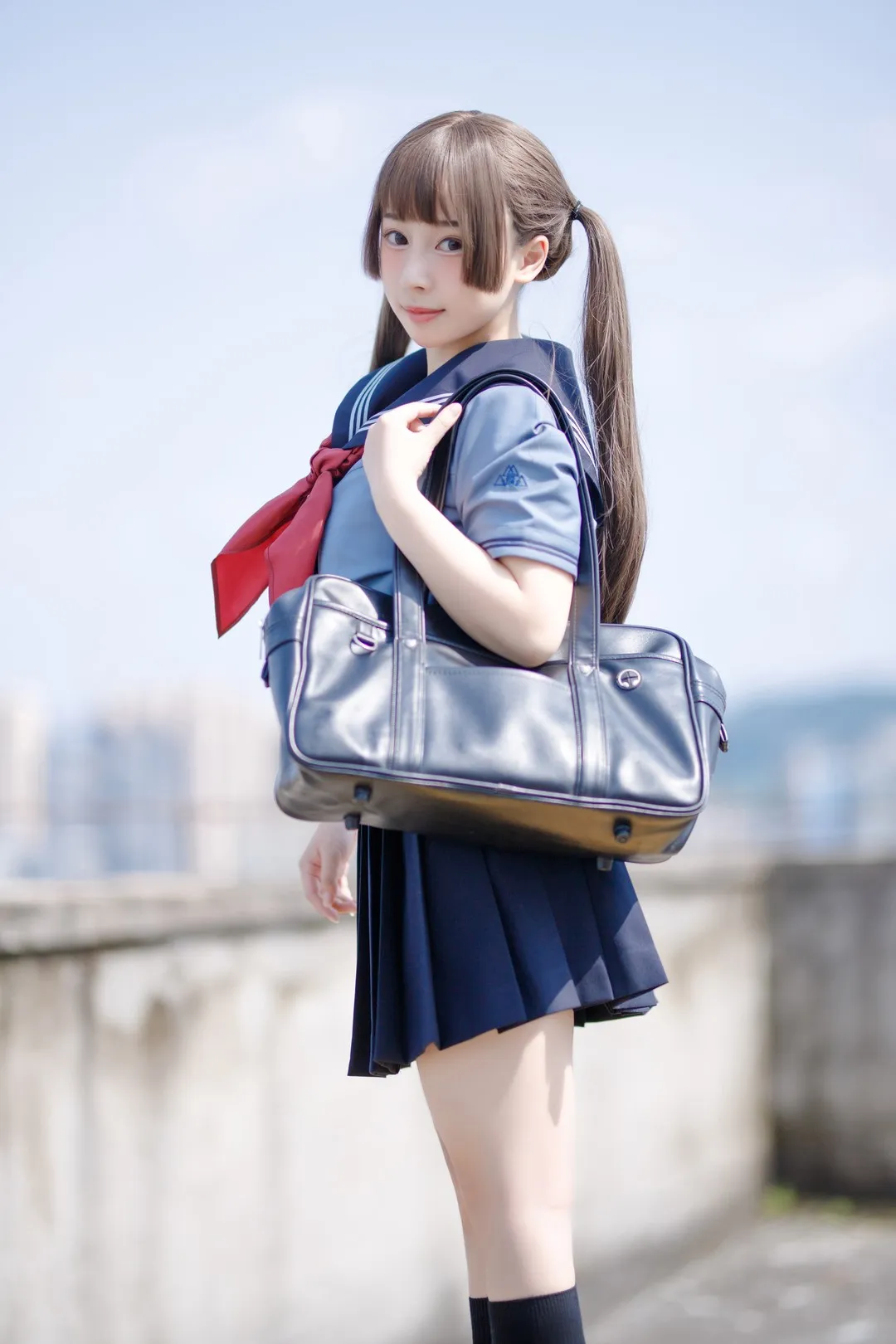 胡桃猫Kurumineko户外水手服双马尾造型,穿蓝色短袖上衣和深色百褶裙,肩背深色包