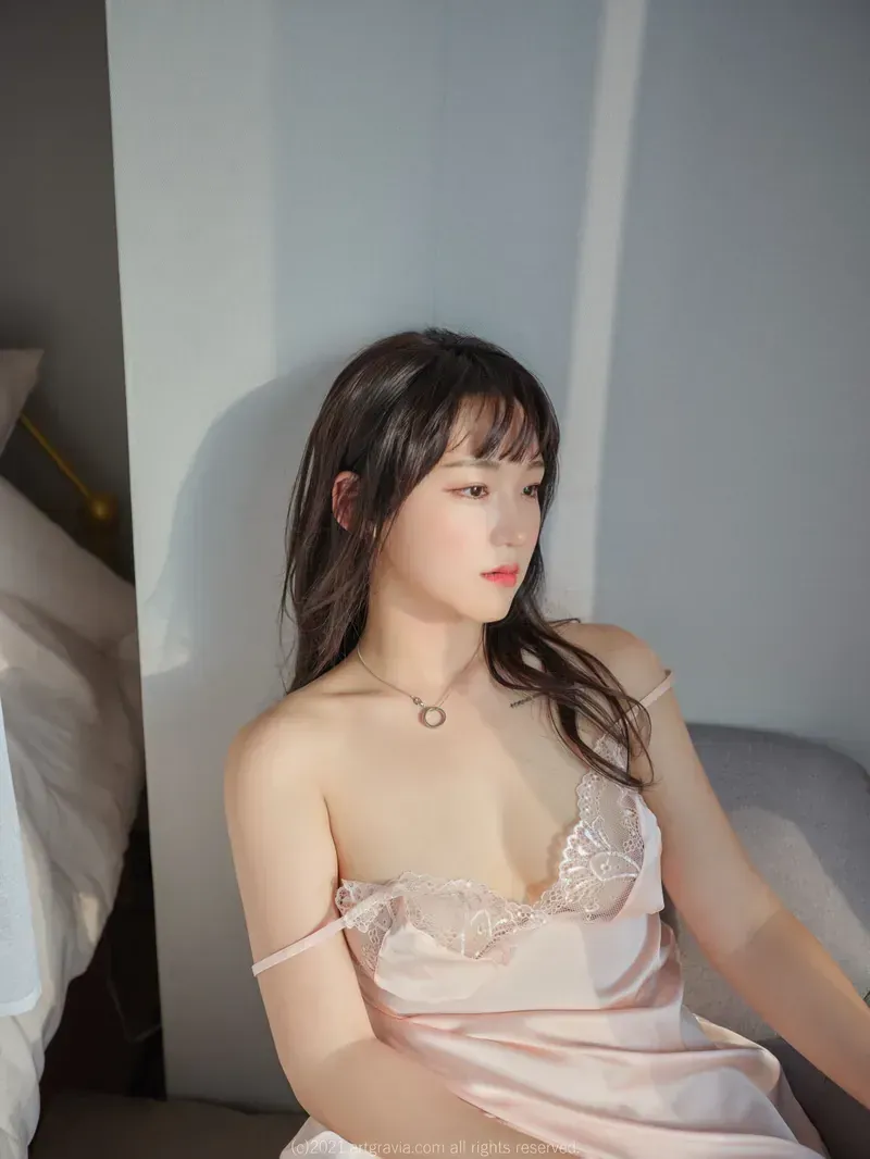 Hendoong(혠둥이)黑色长发、灰色短袖上衣、白色裙装,在白色桌边侧身站立的照片