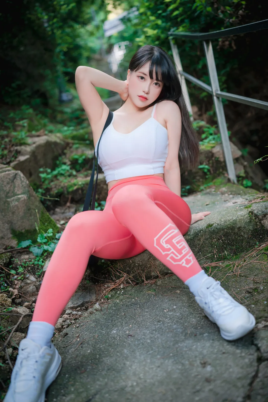ZziZzi(모찌)黑色长发穿白色运动背心和粉色运动裤,坐在山林石阶旁
