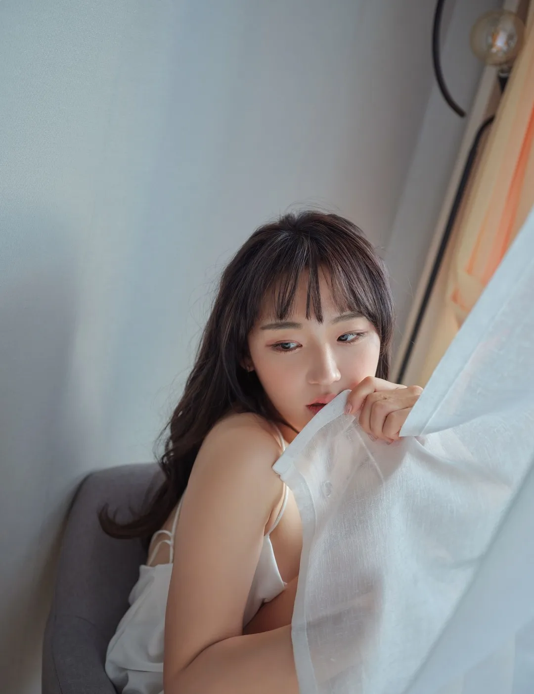 Hendoong(혠둥이)黑色长发、白色高领上衣、蓝灰格纹裙,站在浅色石纹墙前的照片