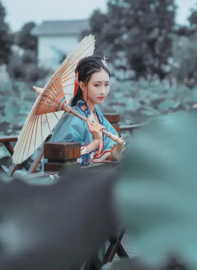Yeri身穿蓝色传统风格服饰手持油纸伞的照片