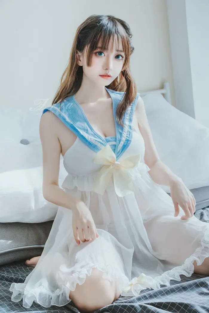神本无尾身穿浅蓝白色服装坐在室内床边的造型照片