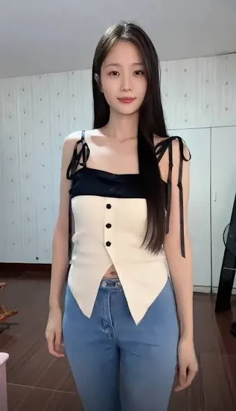 抖音倩倩 人物穿黑白拼接上衣和牛仔裤站在室内的照片