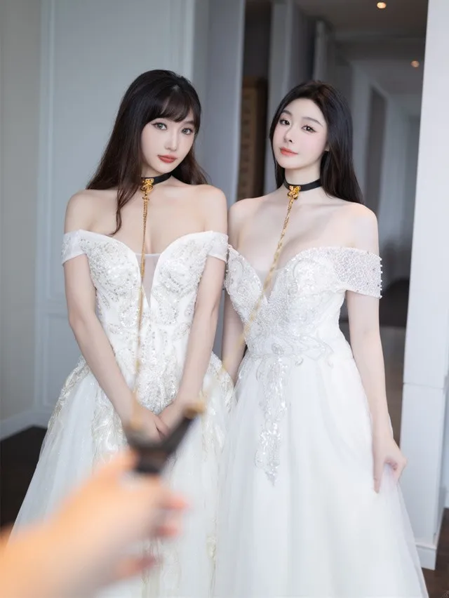 是小逗逗与另一位人物穿白色礼服站在室内的照片