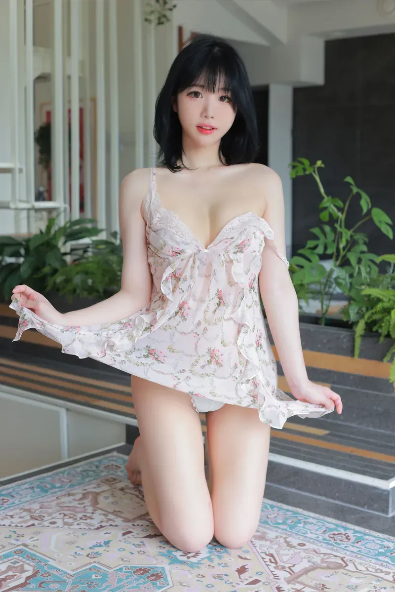 兮嘻嘻穿浅色花纹服装坐在室外空间前的照片