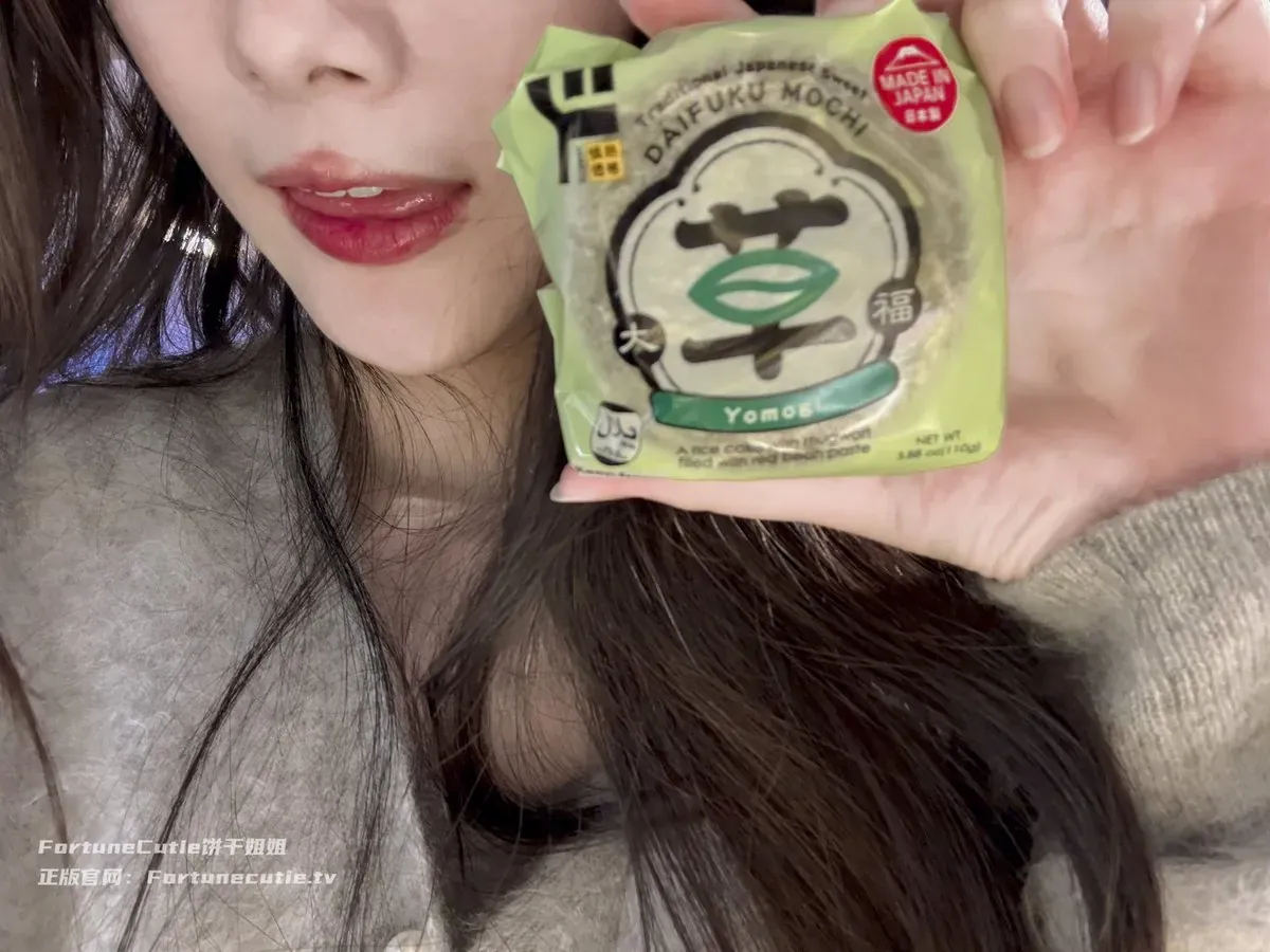 紫氯氯 人物手持绿色包装物的近景照片