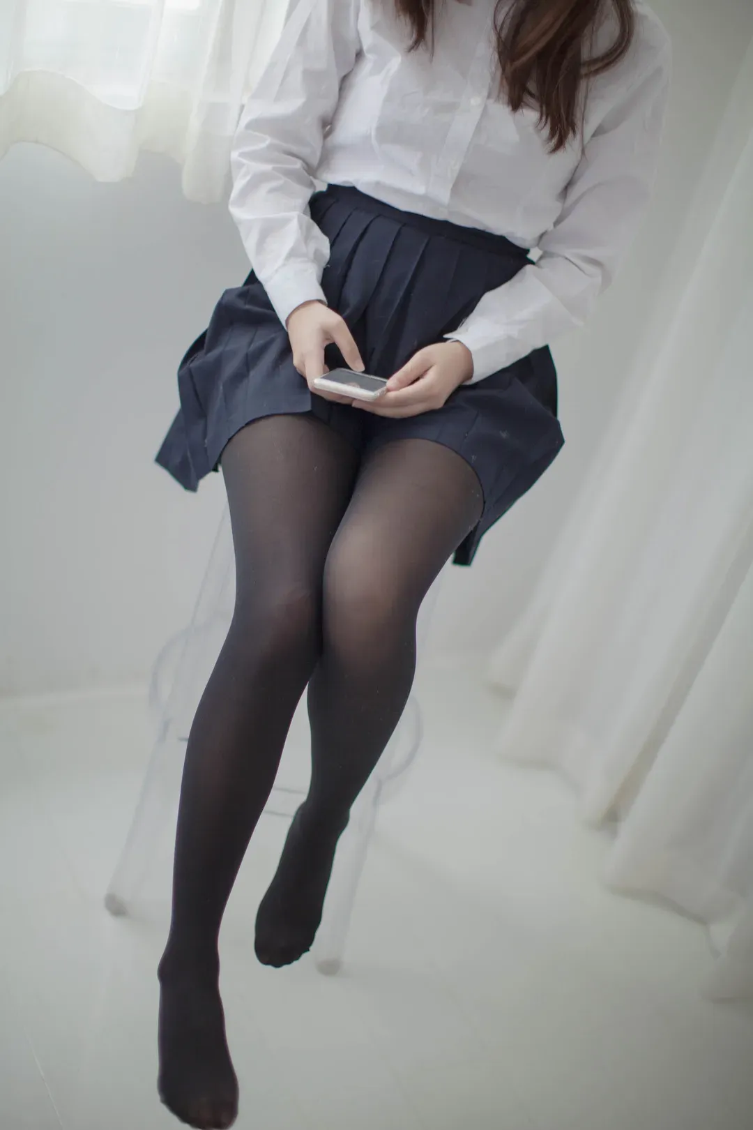 少女秩序坐在室内查看手机的照片