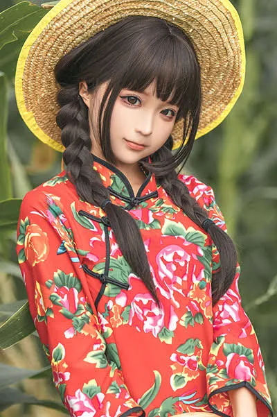 Vickyyyii穿红色花纹服饰并佩戴草帽的户外照片