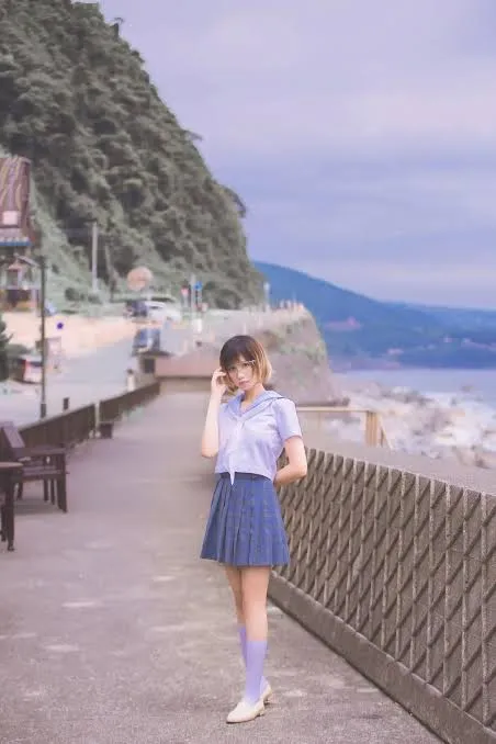 少萝没人爱穿蓝白校园风服饰站在海边步道上的照片