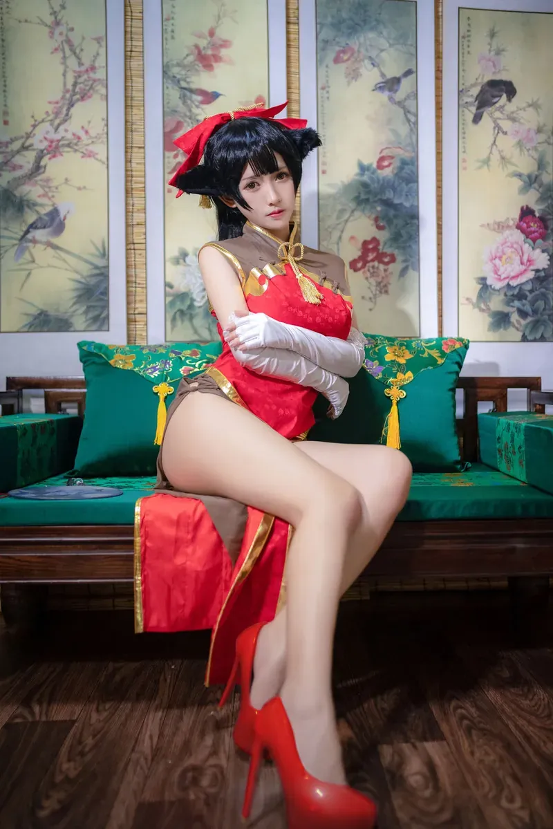 尤妮丝身穿红褐拼色高开叉旗袍搭配红色高跟鞋端坐在中式罗汉床上