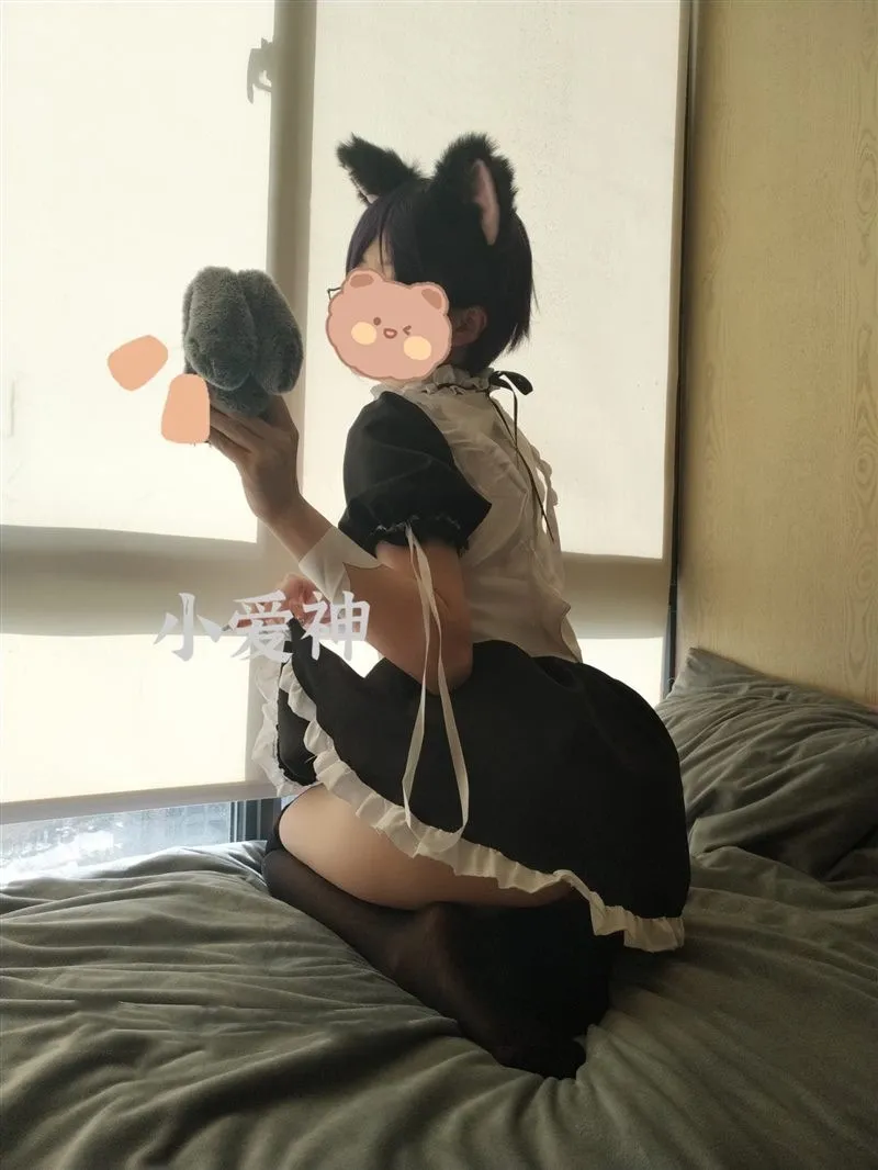 妖怪桃桃子侧跪在灰色床垫上展示猫耳发饰与女仆裙后摆